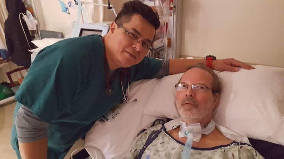 Al in his hospital bed posing with one of his health providers