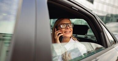 woman on cell phone in taxi looking out window