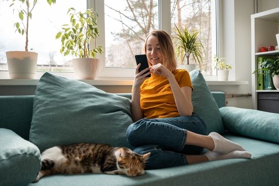 Woman sitting on a couch using cell phone