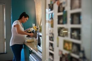 pregnant woman mixing ingredients while reading box instructions