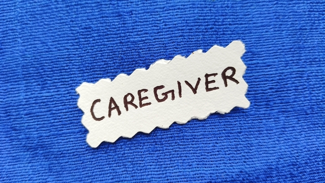 Name tag with the word caregiver written on it