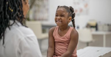 young girl patient smiling at doctor in exam room