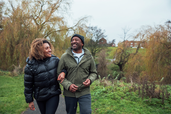 laughing couple walking garden path