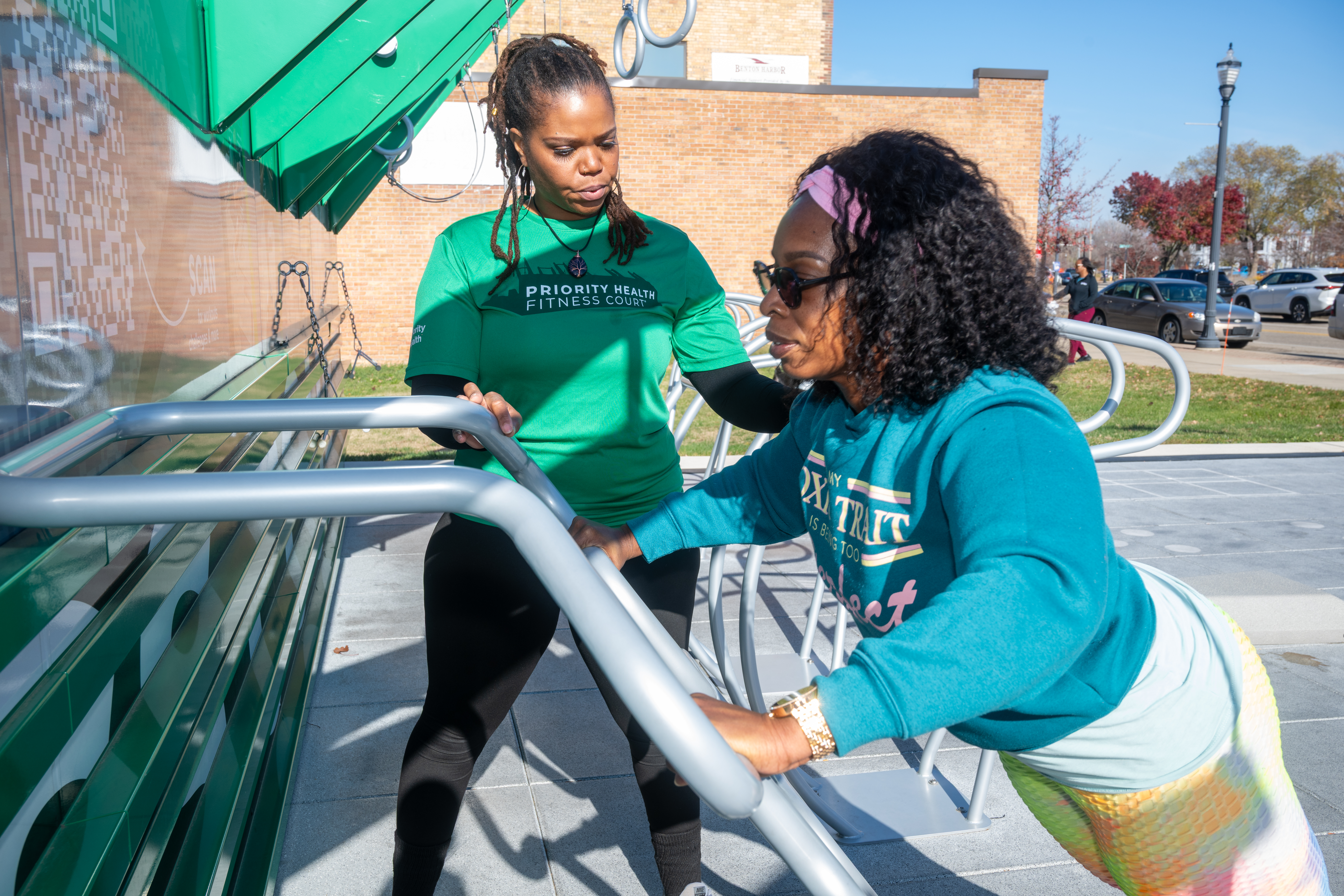 Two women working out at a free, outdoor Priority Health Fitness Court in Benton Harbor, Michigan
