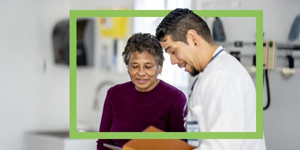 Doctor showing female senior patient test results on tablet