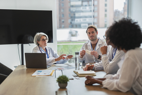 Healthcare professionals in a meeting room reviewing medication options