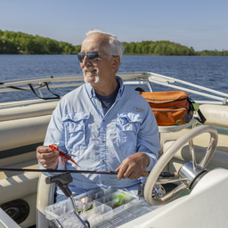 Satch putting a fishing lure on his line in his fighing boat