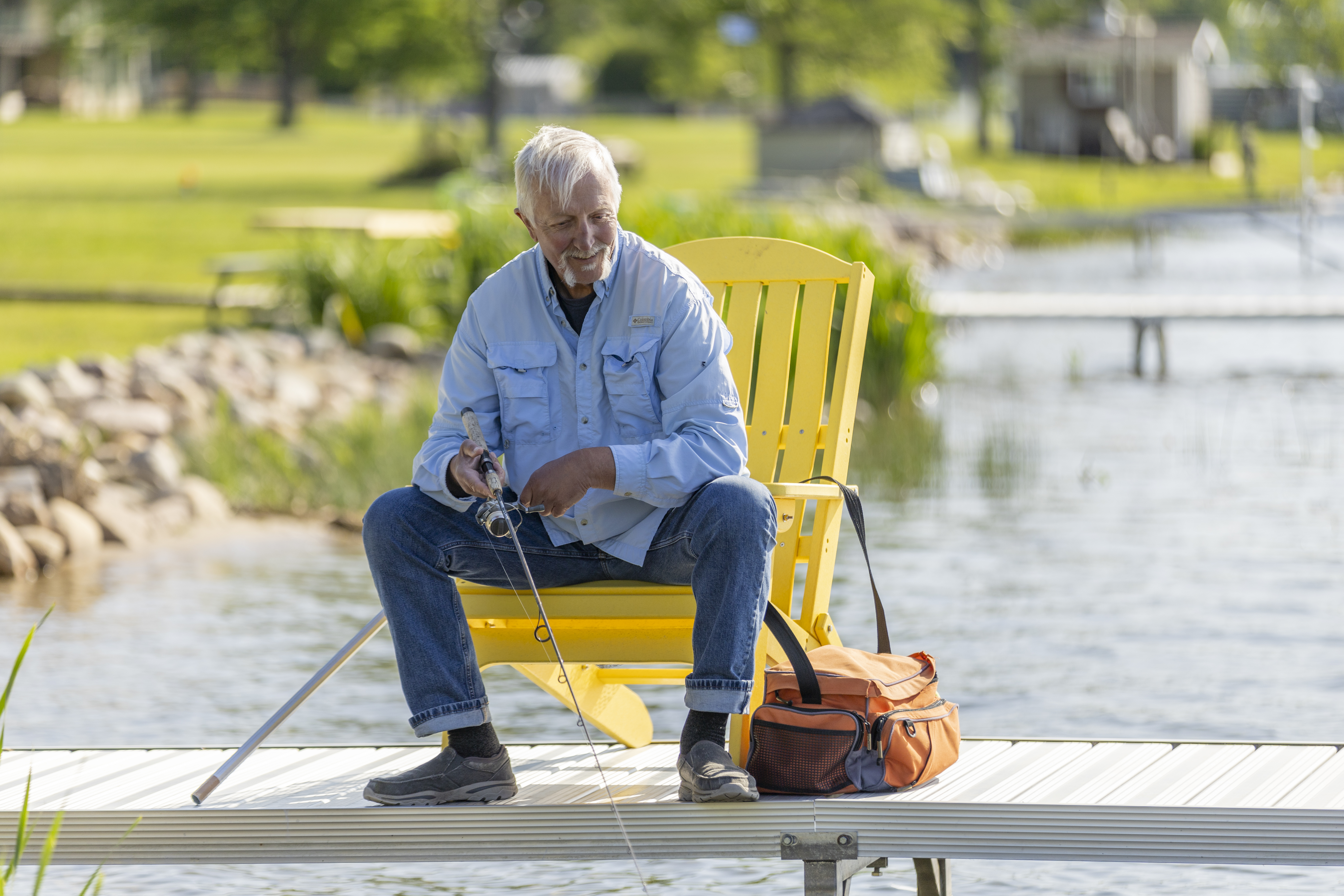Satch sitting on the dock with a fishing line in the water