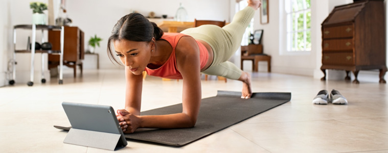 a woman in a yoga pose watching a tablet