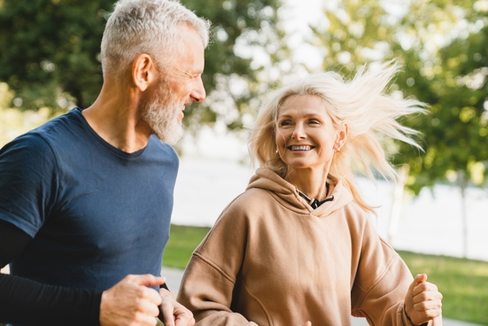 Two adults on a run outside near water