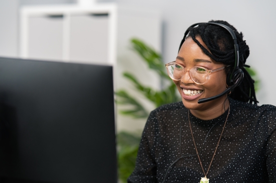 Customer service representative at computer wearing headset 