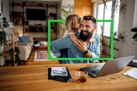 Father and daughter sitting in front of computer