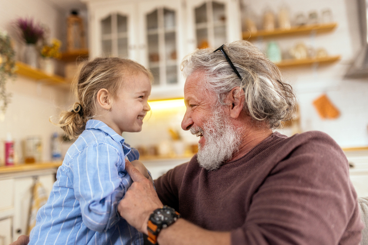 Grandpa and grandchild laughing at home in kitchen