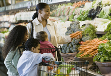 Mom and her children shopping for produce at the grocery store