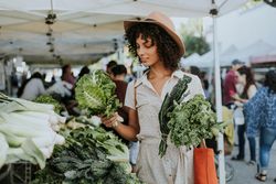 Woman comparing kale and cabbage at farmer's market