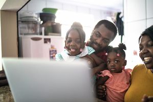 Parents with two young kids looking at computer