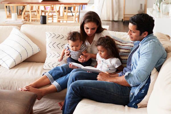 family sitting on couch reading books