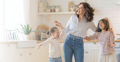 mom dancing with her daughters in the kitchen