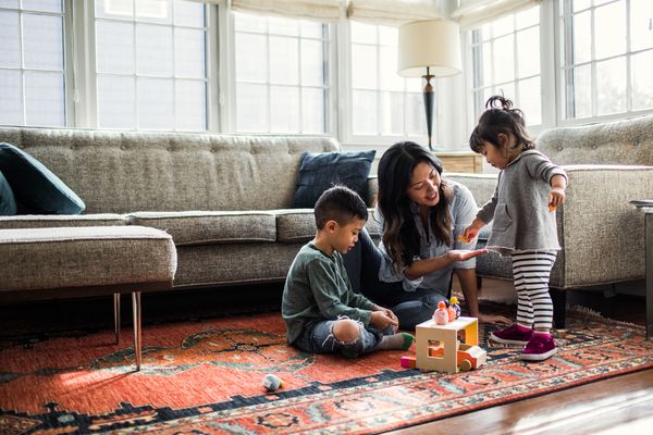 young mother playing with her children on the floor 