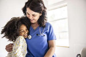 Young patient hugging her provider at the doctor office