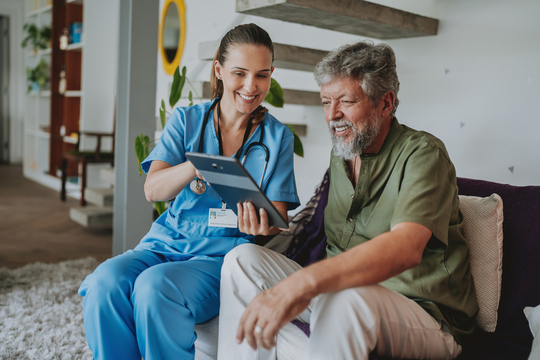 a medical provider sharing information on a tablet with an older man 
