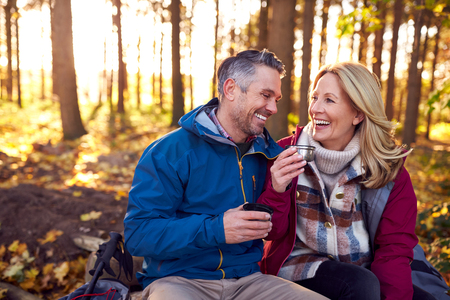 middle age couple drinking coffee in woods