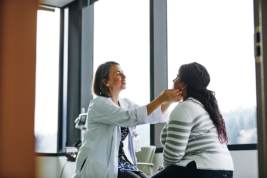 A female doctor feeling the glands of a female patient