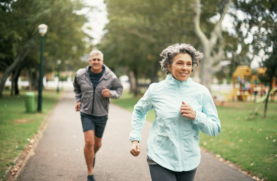 healthy older couple running outdoors in cool weather