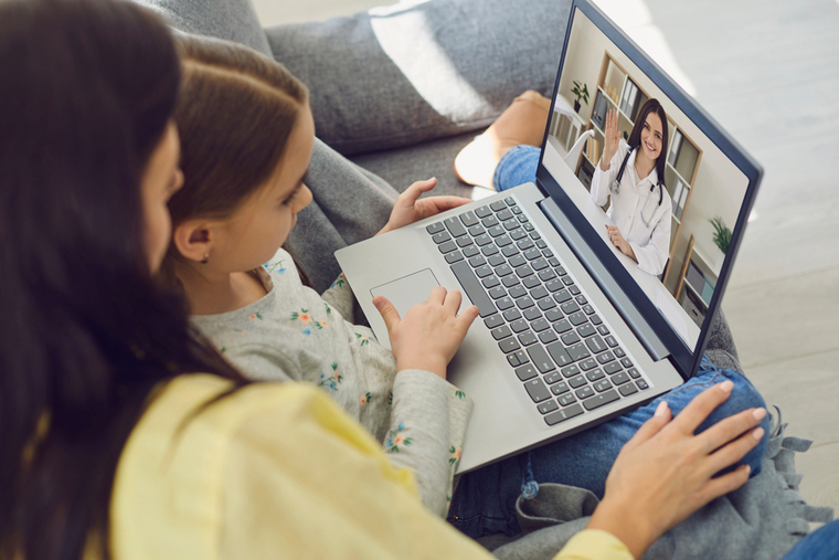 Mom and daughter doing virtual visit on laptop