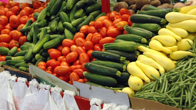 Fresh vegetable display of tomatoes, zucchini and green beans