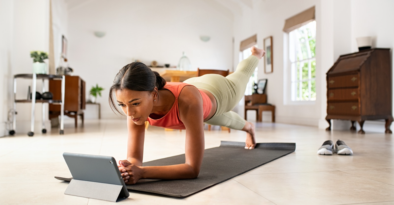 a woman in a yoga pose watching a tablet