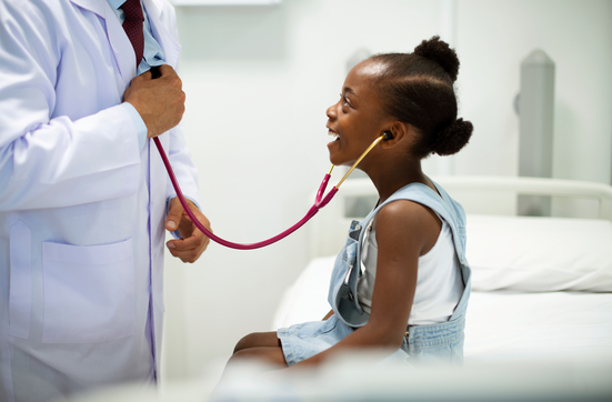 girl patient listening to doctor's heartbeat in exam room.