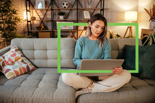 Young woman sitting on couch with computer