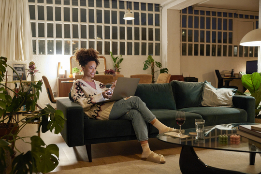 woman working on laptop in room full of houseplants