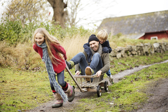 Daughter pulling father and younger brother in wagon