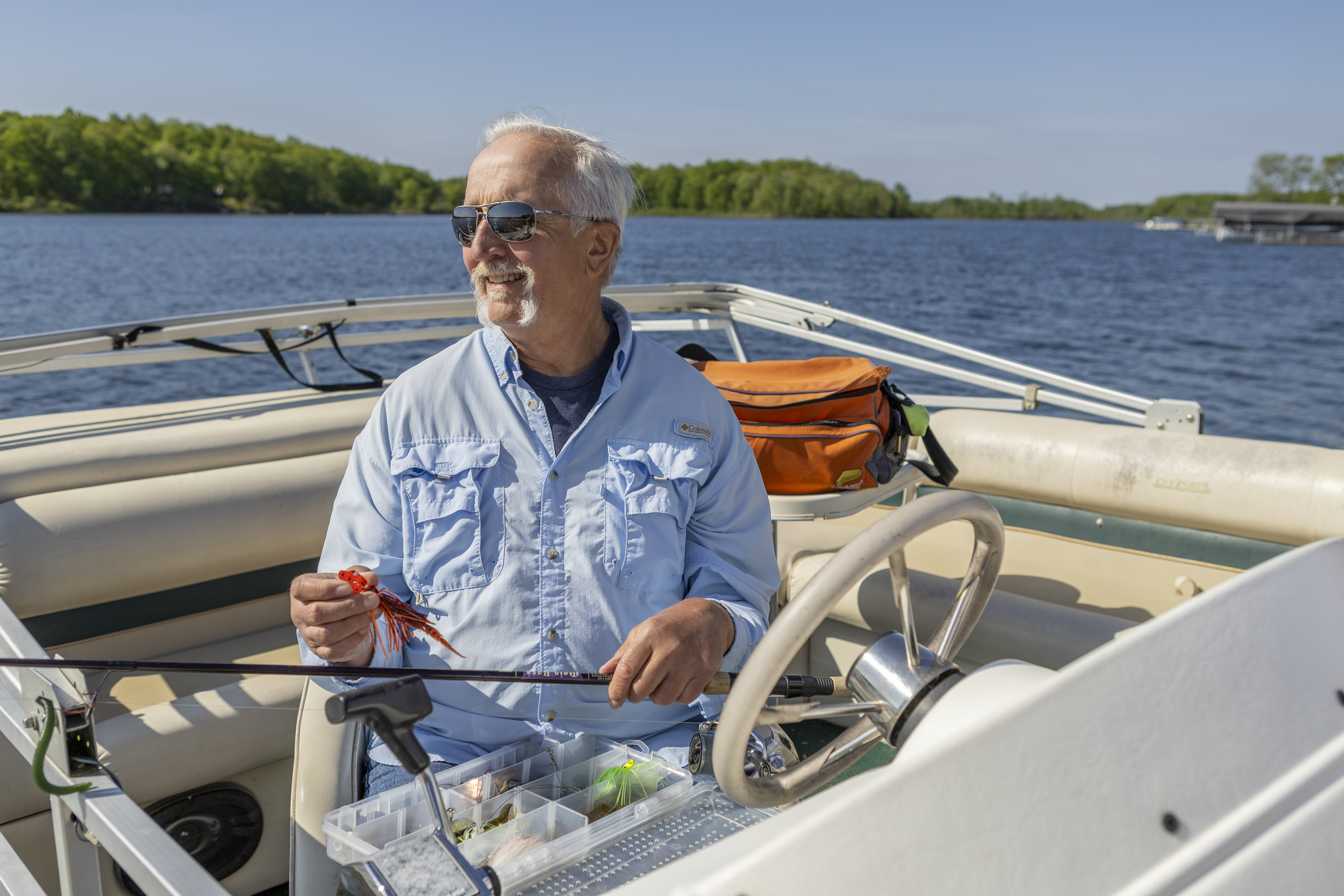 Satch putting a fishing lure on his line in his fighing boat