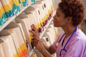 a provider looking at a shelf of medical records files.