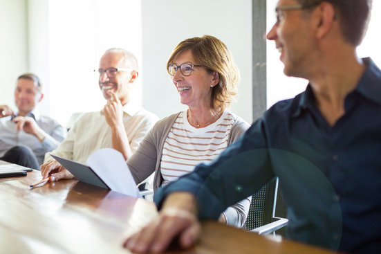 smiling coworkers at boardroom table in meeting