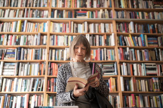 Woman standing in front of large shelves of books