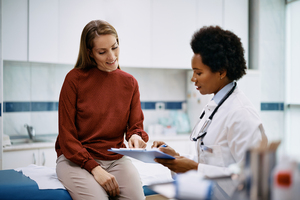 Woman provider talking to a patient in an exam room