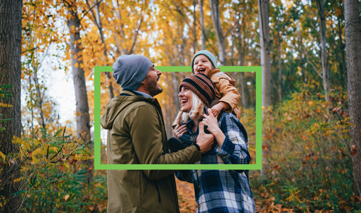 Young family on a walk in the woods in autumn