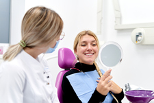Young woman at the dentist looking in the mirror