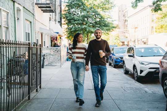 Young couple holding hands walking in the city