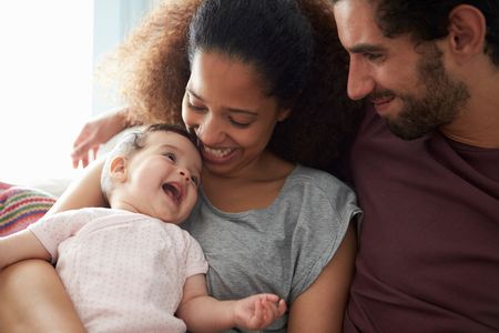 Young couple holding smiling baby