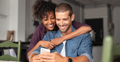 smiling young couple looking at phone