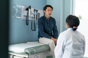 Man sitting in exam room talking with a female doctor