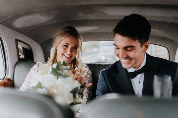 Bride and groom in limo smiling