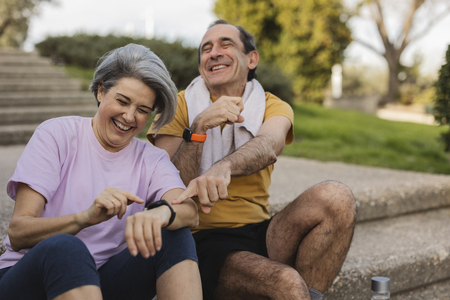 older couple laughing at fitness trackers post-workout