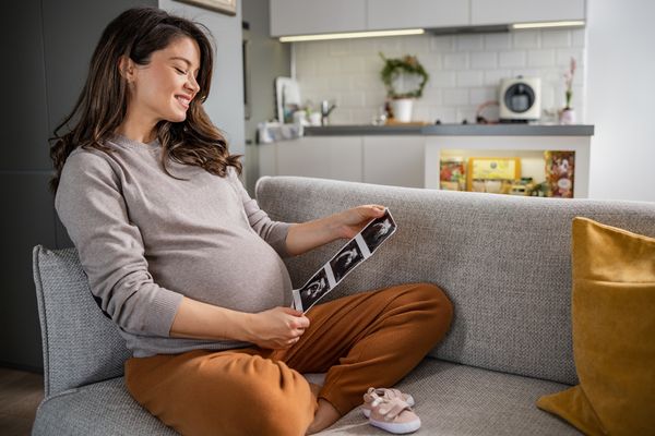 pregnant mom on couch with ultrasound pictures